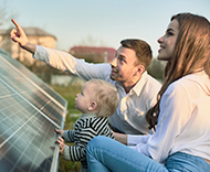 Eltern mit kleinem Kind betrachten gemeinsam eine Solaranlage